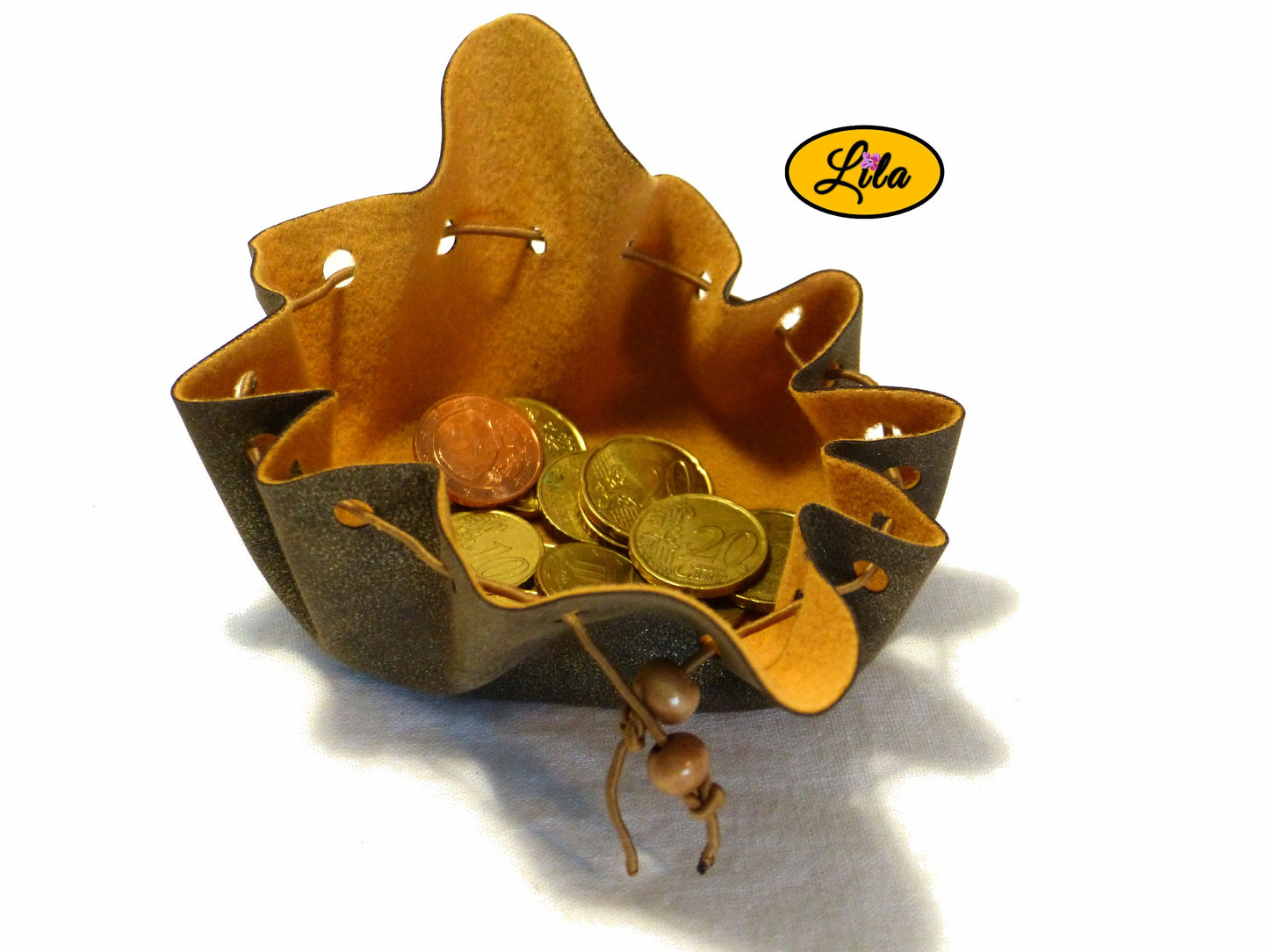 Bourse brune effet doré en simili cuir ouverte vue de haut avec pièces de monnaie visibles à l’intérieur sur fond blanc style pratique et artisanal