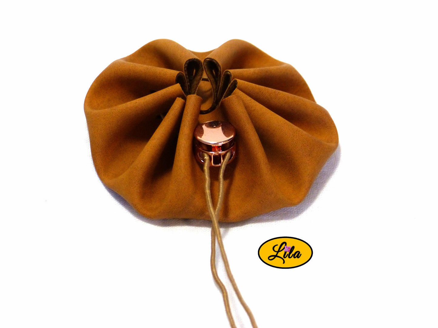 Bourse ronde brune en simili cuir avec fermeture à cordon brun et pince ronde rosée vue de face sur fond blanc style bohème chic et artisanal