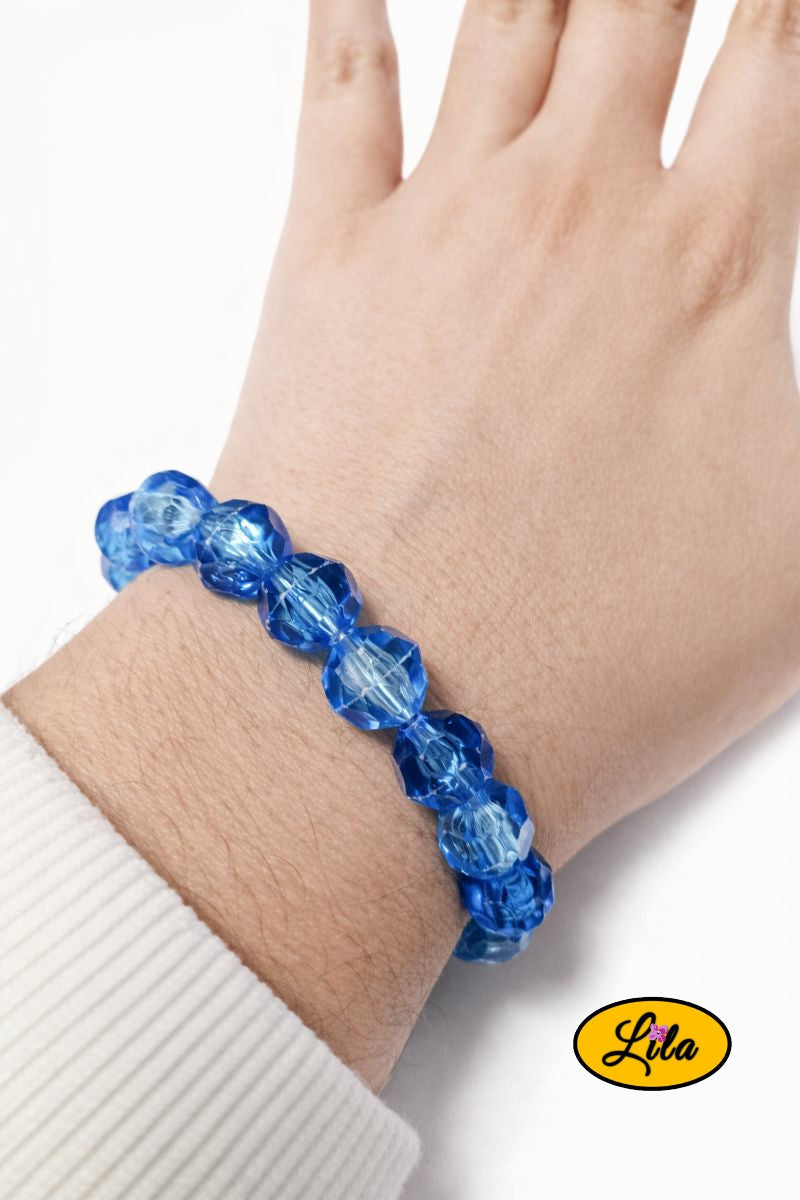 Bracelet en grosses perles bleues vintage porté au poignet style élégant