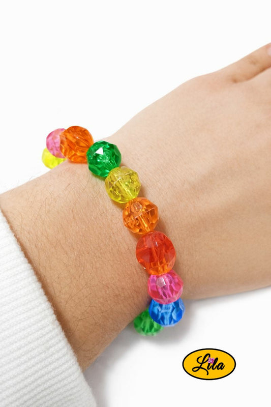 Bracelet en grosses perles multicolores vintage porté au poignet style coloré