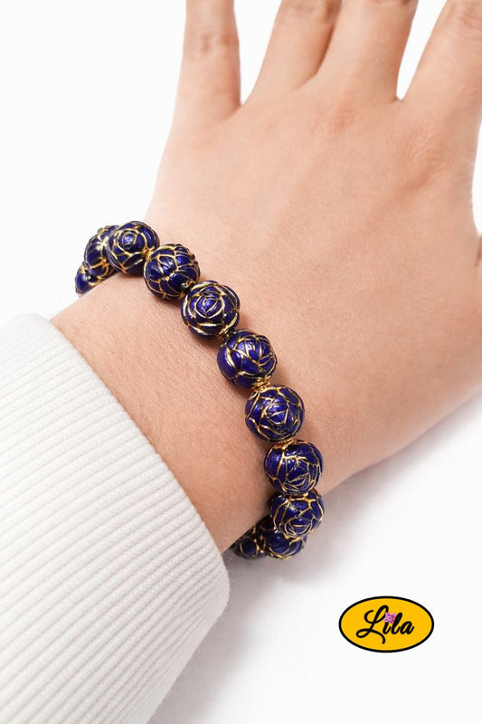 Bracelet avec perles bleues formant une fleur porté au poignet style délicat