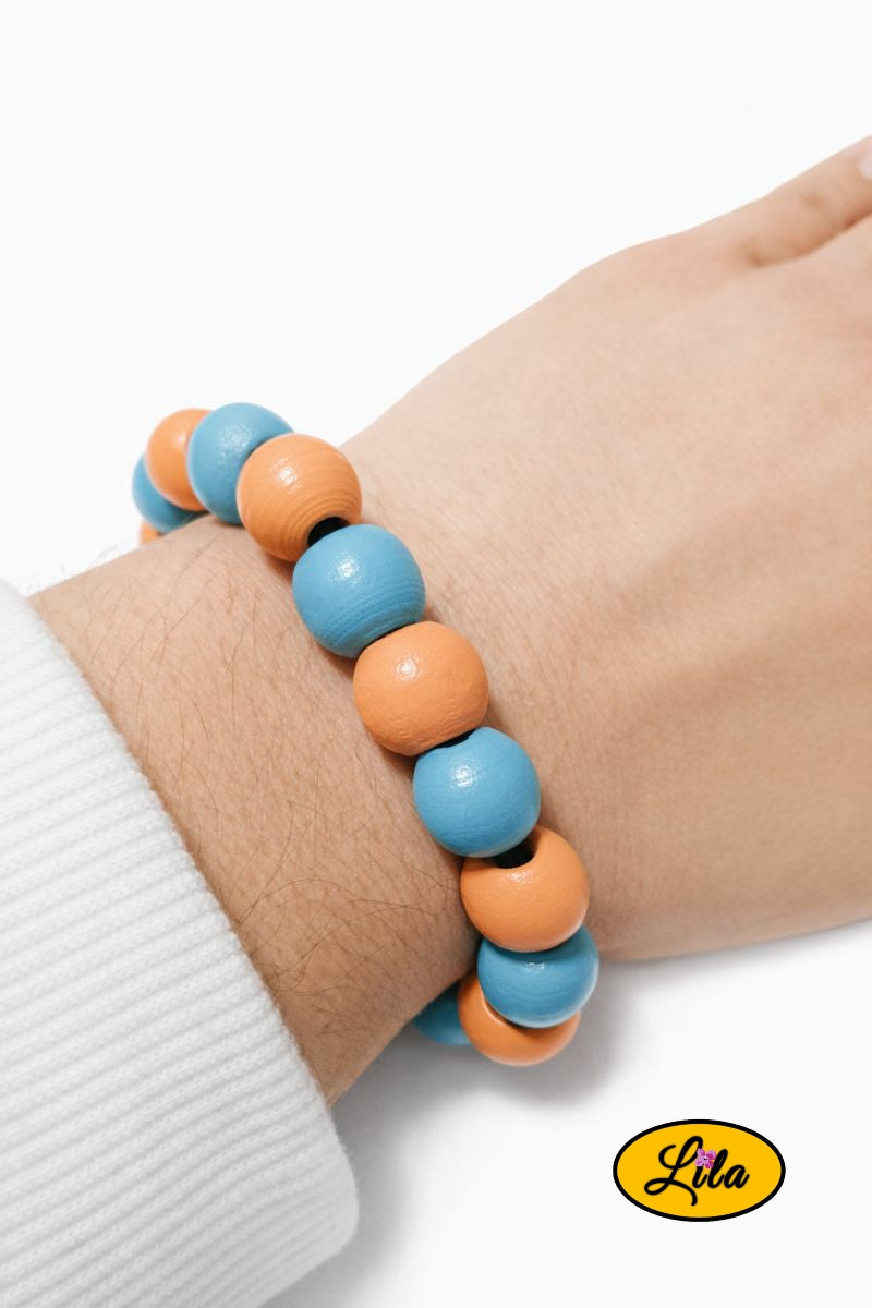 Bracelet en perles rondes en bois bleu et orange porté au poignet style coloré