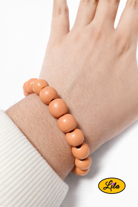 Bracelet en perles rondes en bois orange porté au poignet style naturel