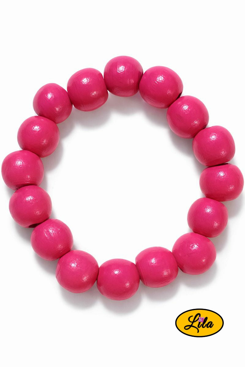Détail bracelet perles rondes en bois rose foncé vue rapprochée