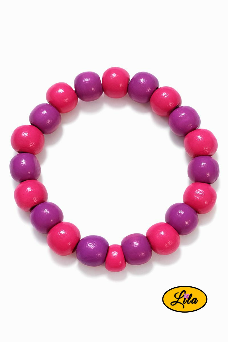 Détail bracelet perles rondes en bois rose et mauve en alternance vue rapprochée