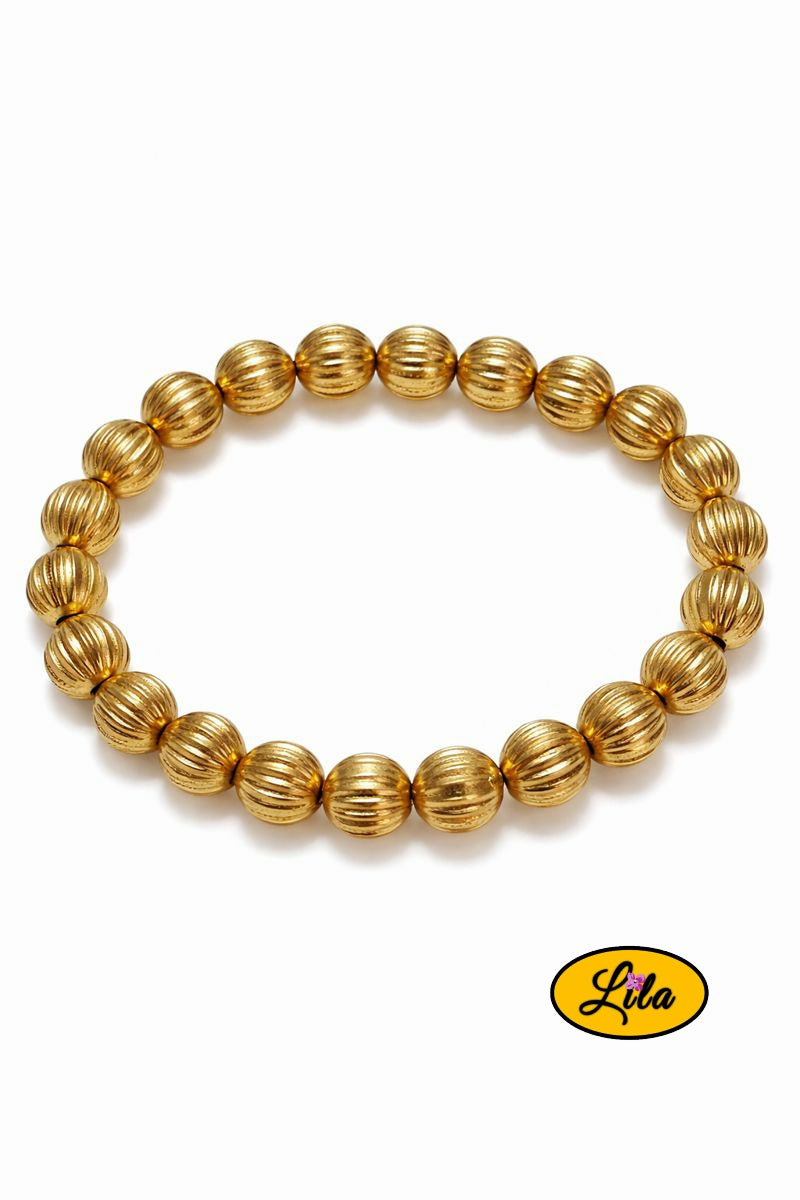 Détail bracelet perles dorées rayées vue rapprochée