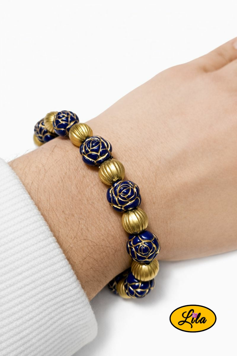 Bracelet avec perles bleues en forme de fleur alternées avec perles dorées porté au poignet style élégant