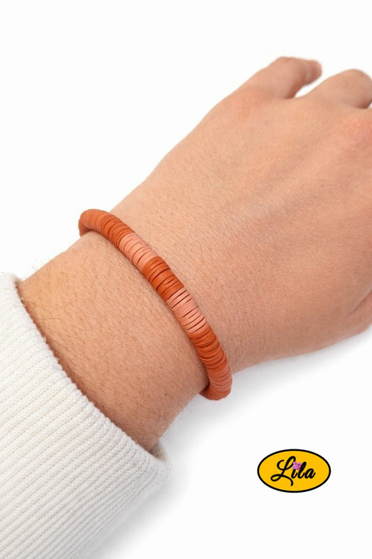 Bracelet en perles Heishi avec deux teintes de brun porté au poignet style naturel