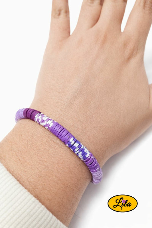 Bracelet en perles Heishi avec différentes nuances de mauve porté au poignet style doux