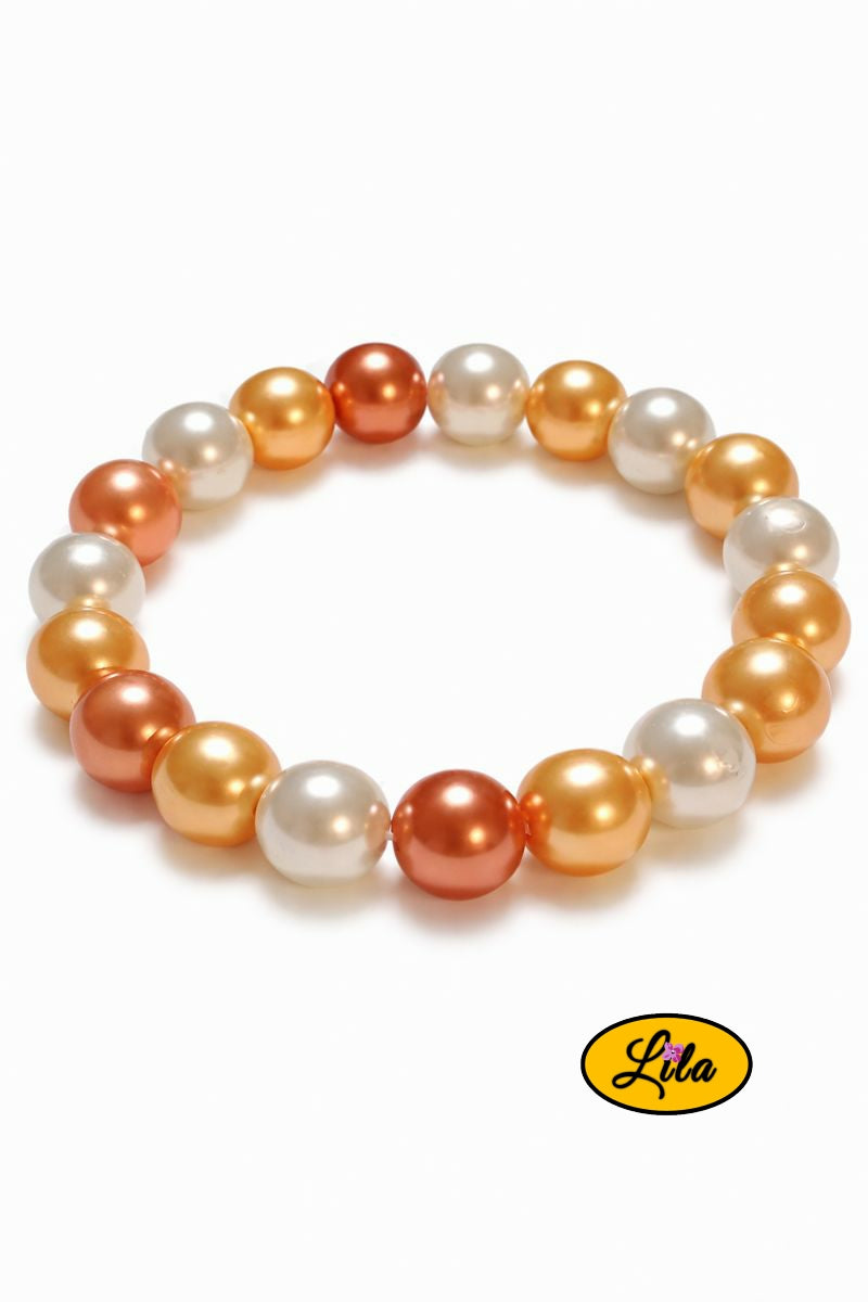 Détail bracelet perles nacrées blanches jaunes et orange en alternance vue rapprochée