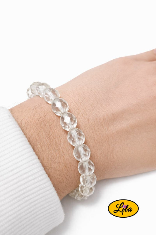 Bracelet en fausses perles translucides porté au poignet style lumineux