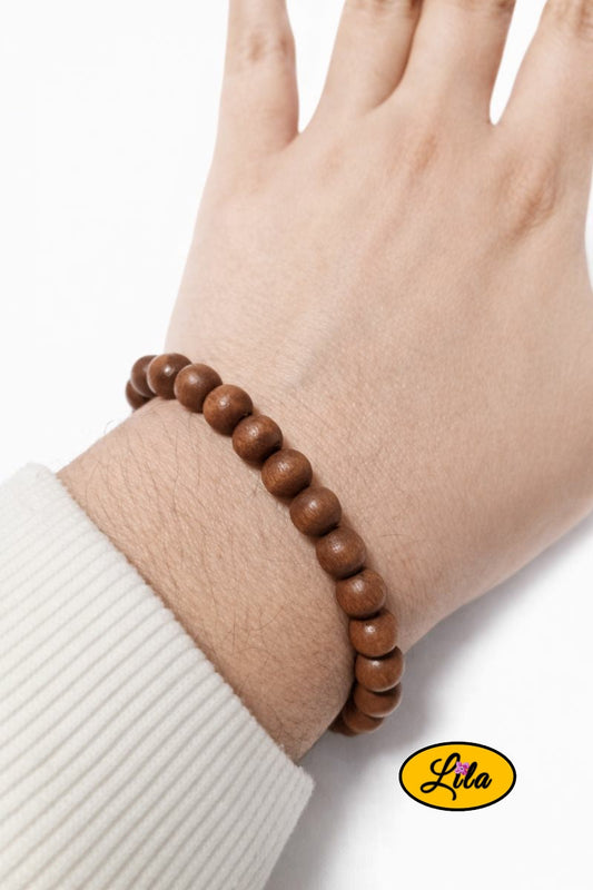 Bracelet en petites perles rondes en bois porté au poignet style naturel minimaliste