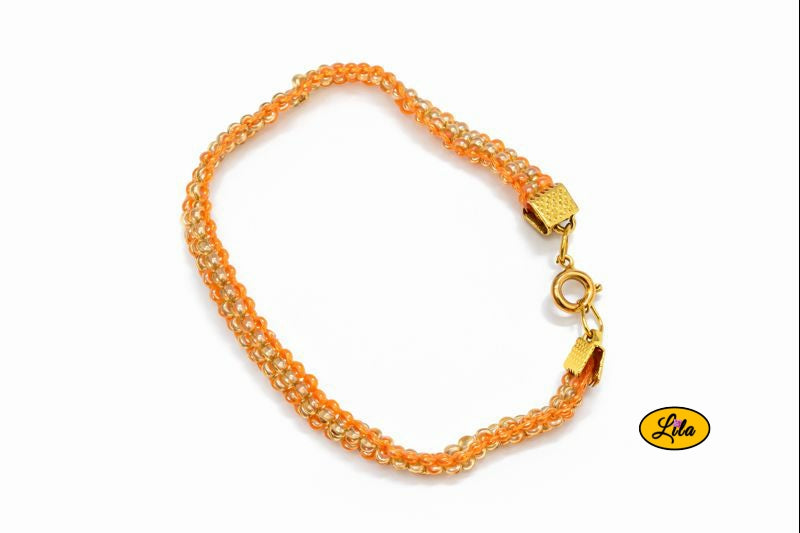 Bracelet tissé perles de rocailles orange et doré vue de dessus sur fond blanc