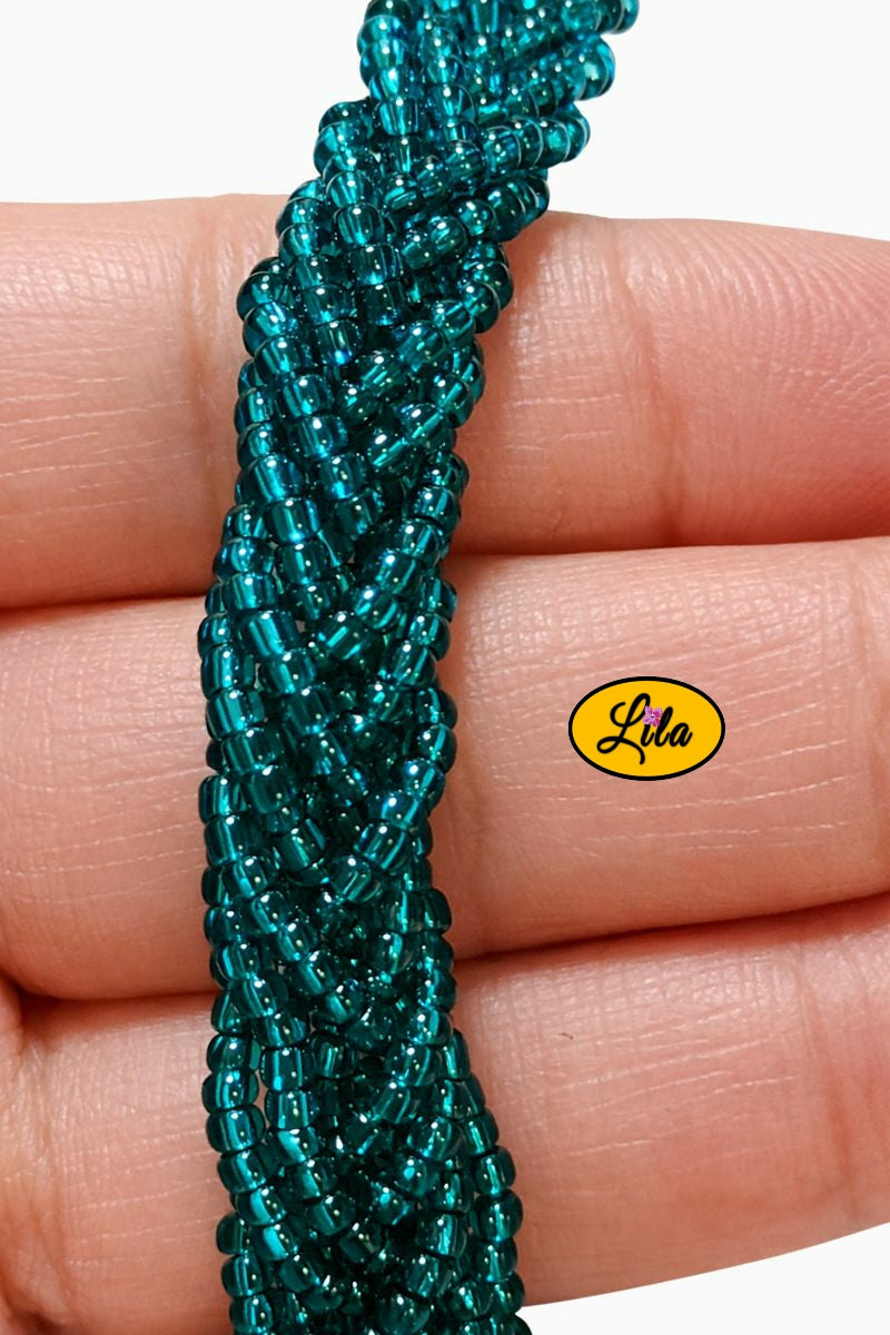 Détail tressage bracelet en perles de rocaille turquoise tenu en main