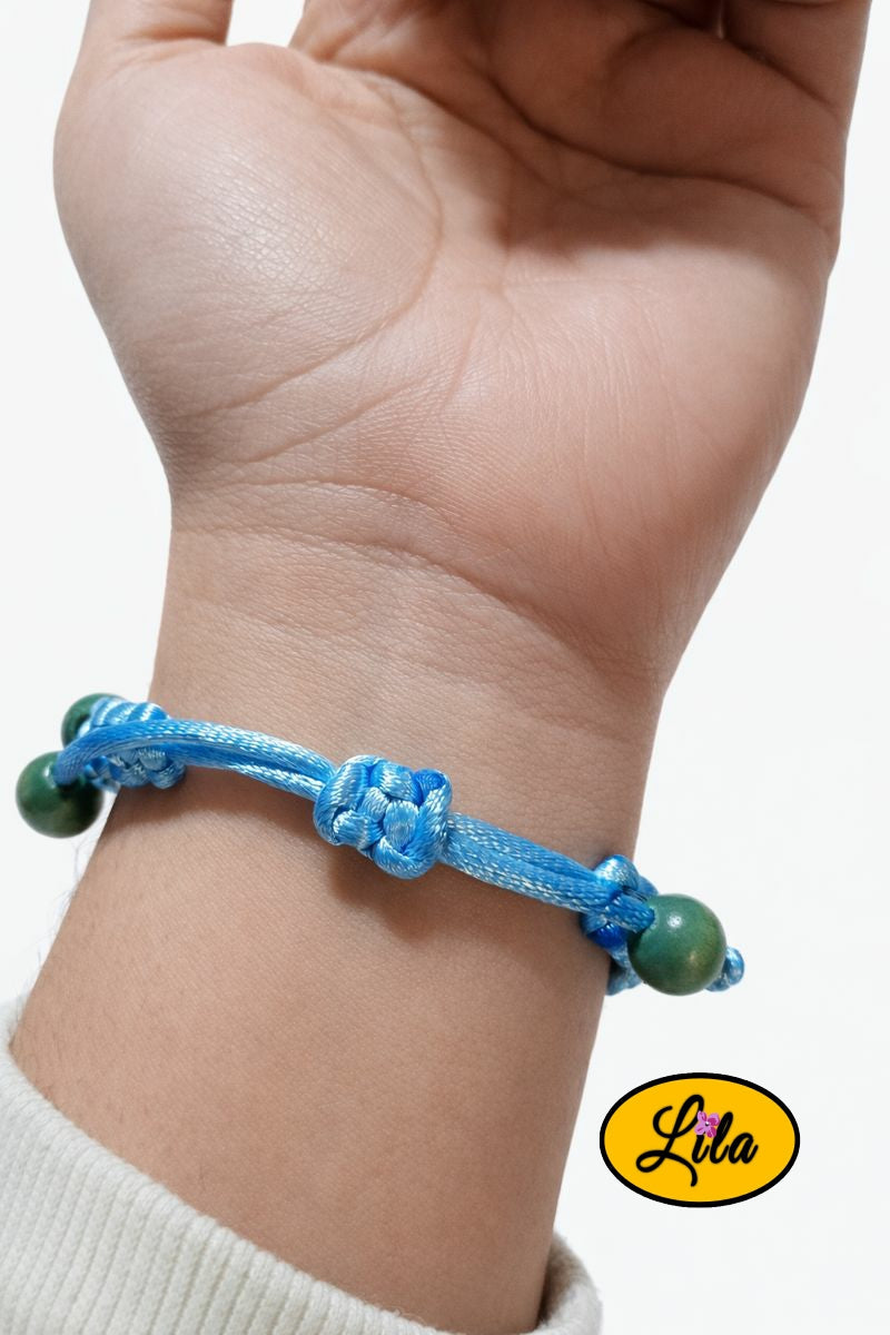 Bracelet Shamballa fil bleu clair avec fermoir coulissant visible paume vers le haut