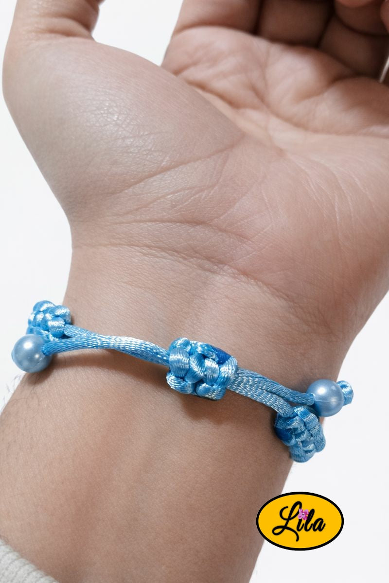 Bracelet Shamballa fil bleu clair avec fermoir coulissant visible paume vers le haut