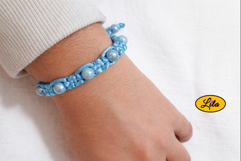 Bracelet Shamballa fil bleu clair avec perles bleues porté au poignet style moderne