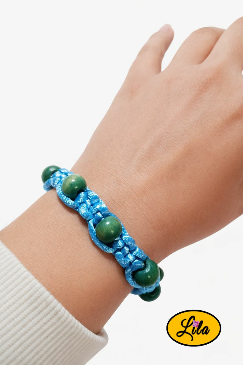 Bracelet Shamballa fil bleu clair avec perles de bois bleues et vertes porté au poignet style naturel