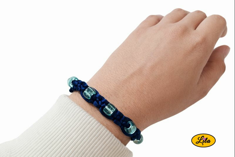 Bracelet Shamballa fil bleu avec perles bleues transparentes porté au poignet style lumineux