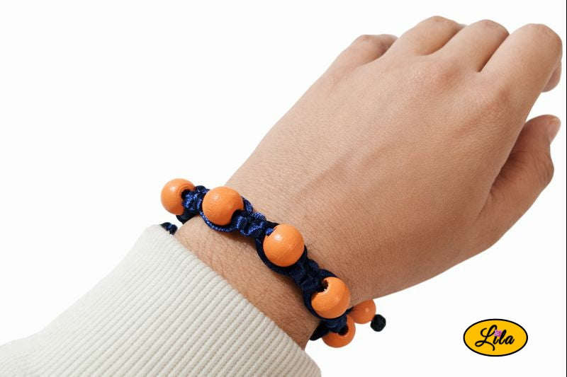 Bracelet Shamballa fil bleu avec perles de bois orange porté au poignet style contrasté