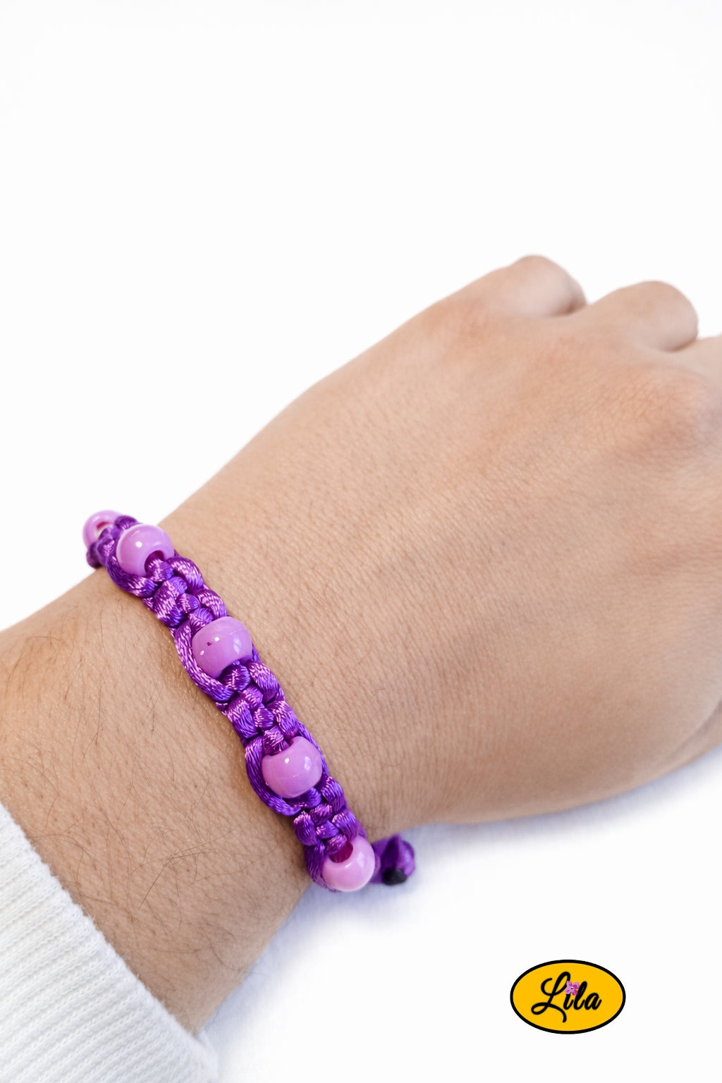 Bracelet Shamballa fil mauve avec perles roses porté au poignet style doux et féminin