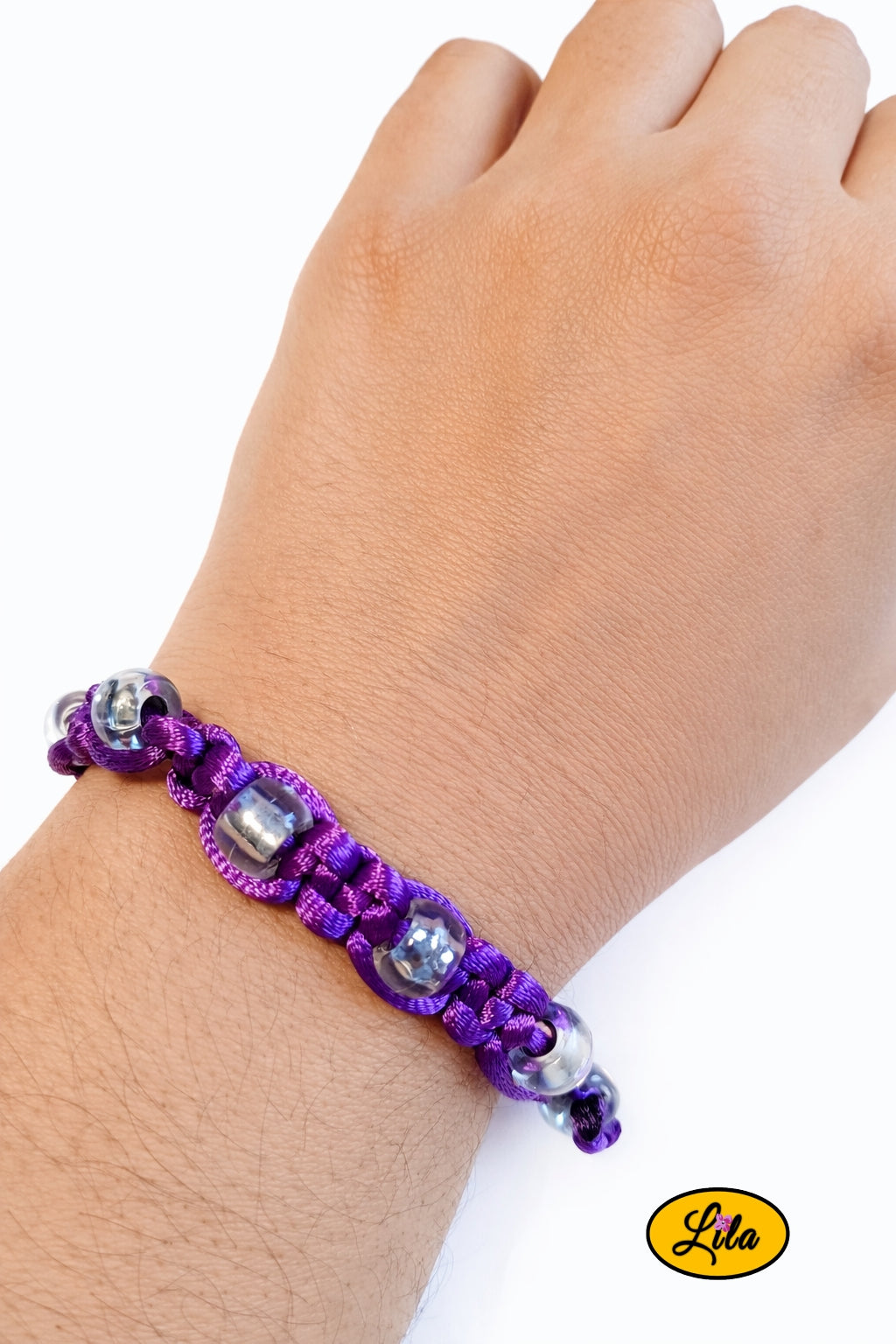 Bracelet Shamballa fil mauve avec perles transparentes porté au poignet style lumineux