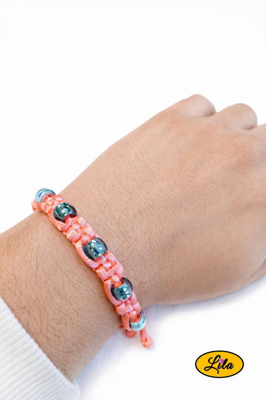 Bracelet Shamballa fil rose avec perles bleues transparentes porté au poignet style lumineux