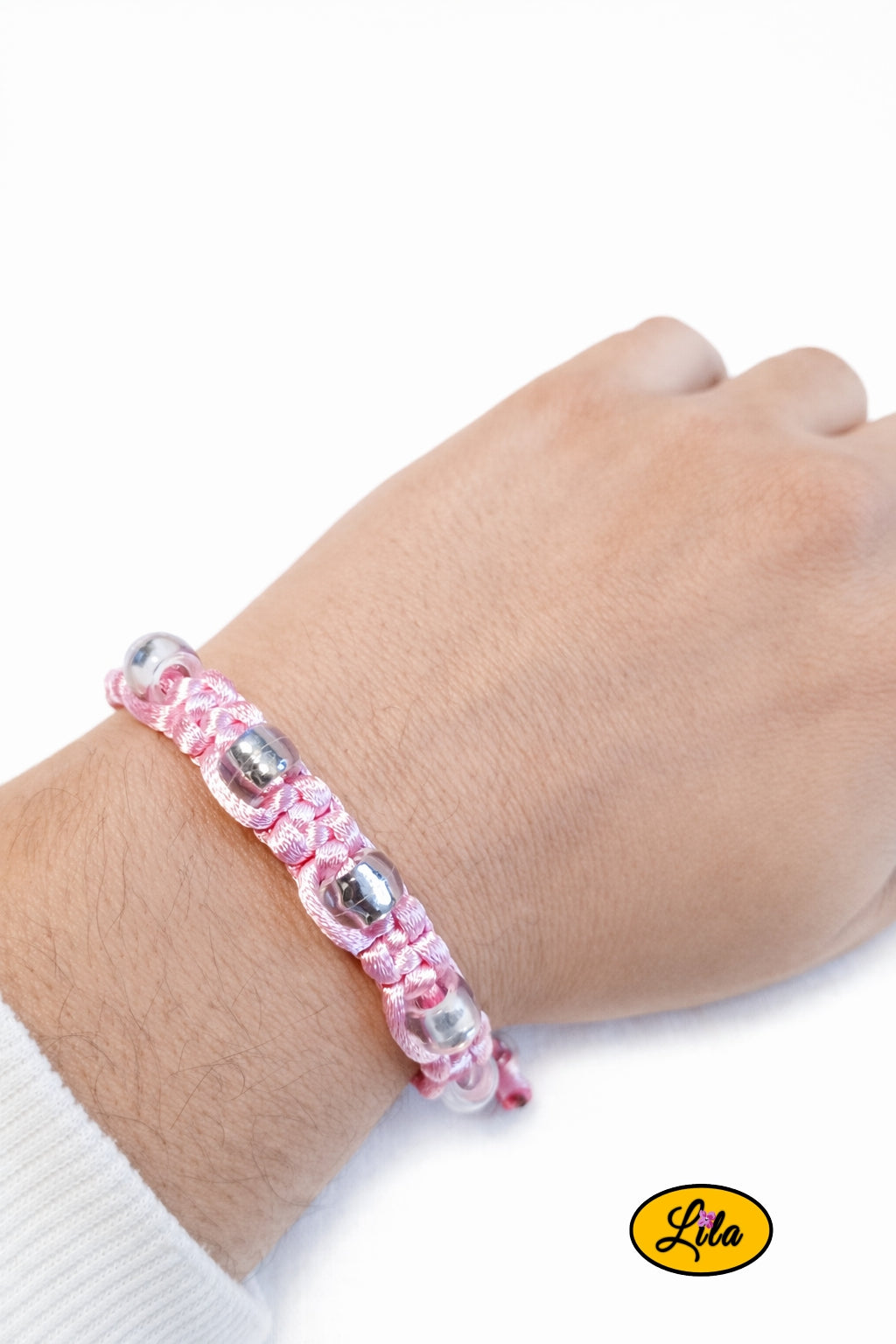 Bracelet Shamballa fil rose avec perles transparentes porté au poignet style lumineux