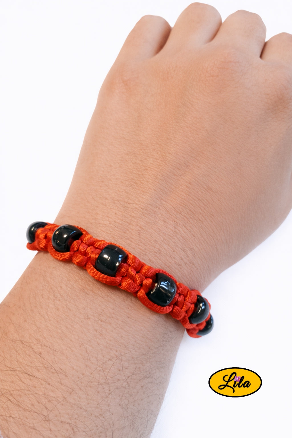 Bracelet Shamballa fil rouge avec perles noires transparentes porté au poignet style moderne