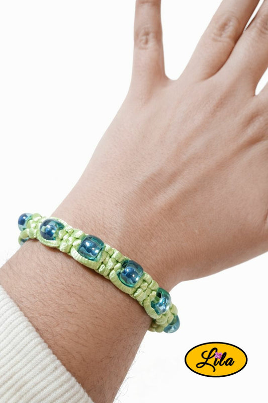 Bracelet Shamballa fil vert clair avec perles bleues argentées porté au poignet style moderne