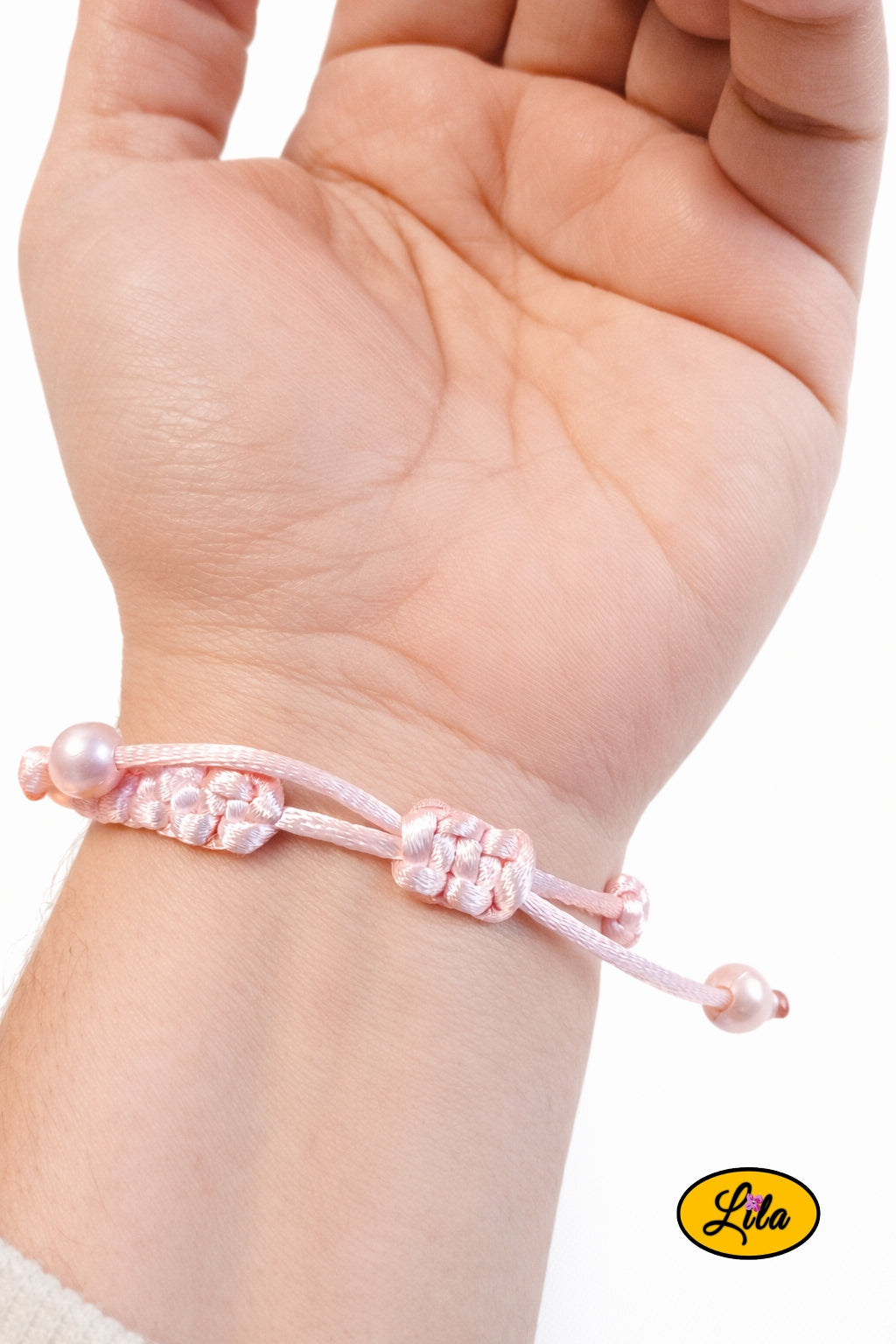 Bracelet Shamballa fil rose clair avec fermoir coulissant visible paume vers le haut