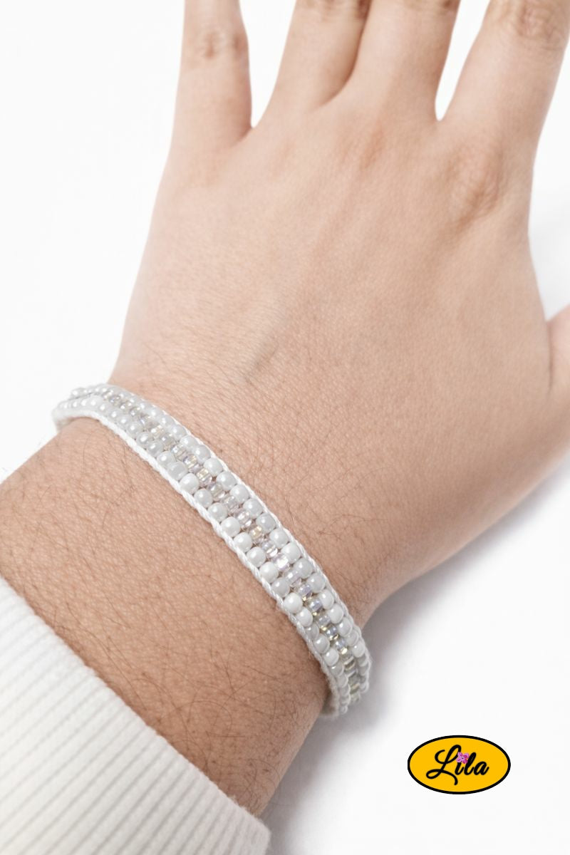 Bracelet tissé en perles de rocailles blanches porté au poignet style élégant