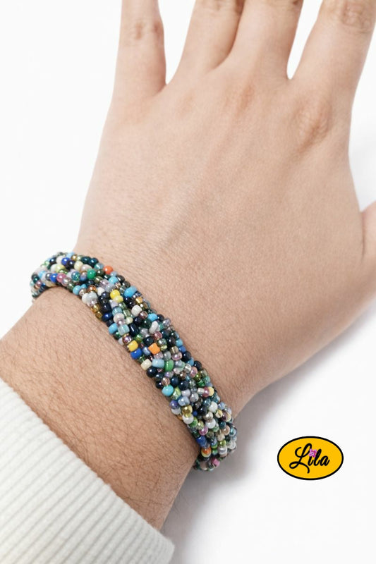 Bracelet tressé en perles de rocaille multicolores porté au poignet style artisanal