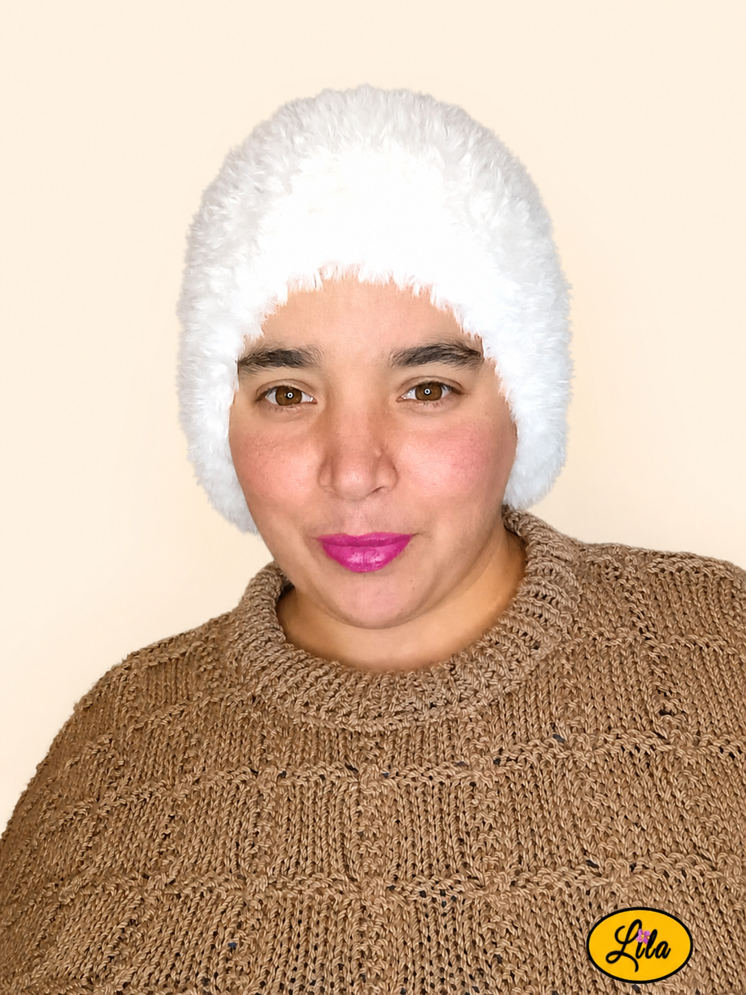 Cache-cou tricoté main en laine effet fausse fourrure blanche porté par une femme avec pull brun sur fond crème vue de face style cocooning et élégant