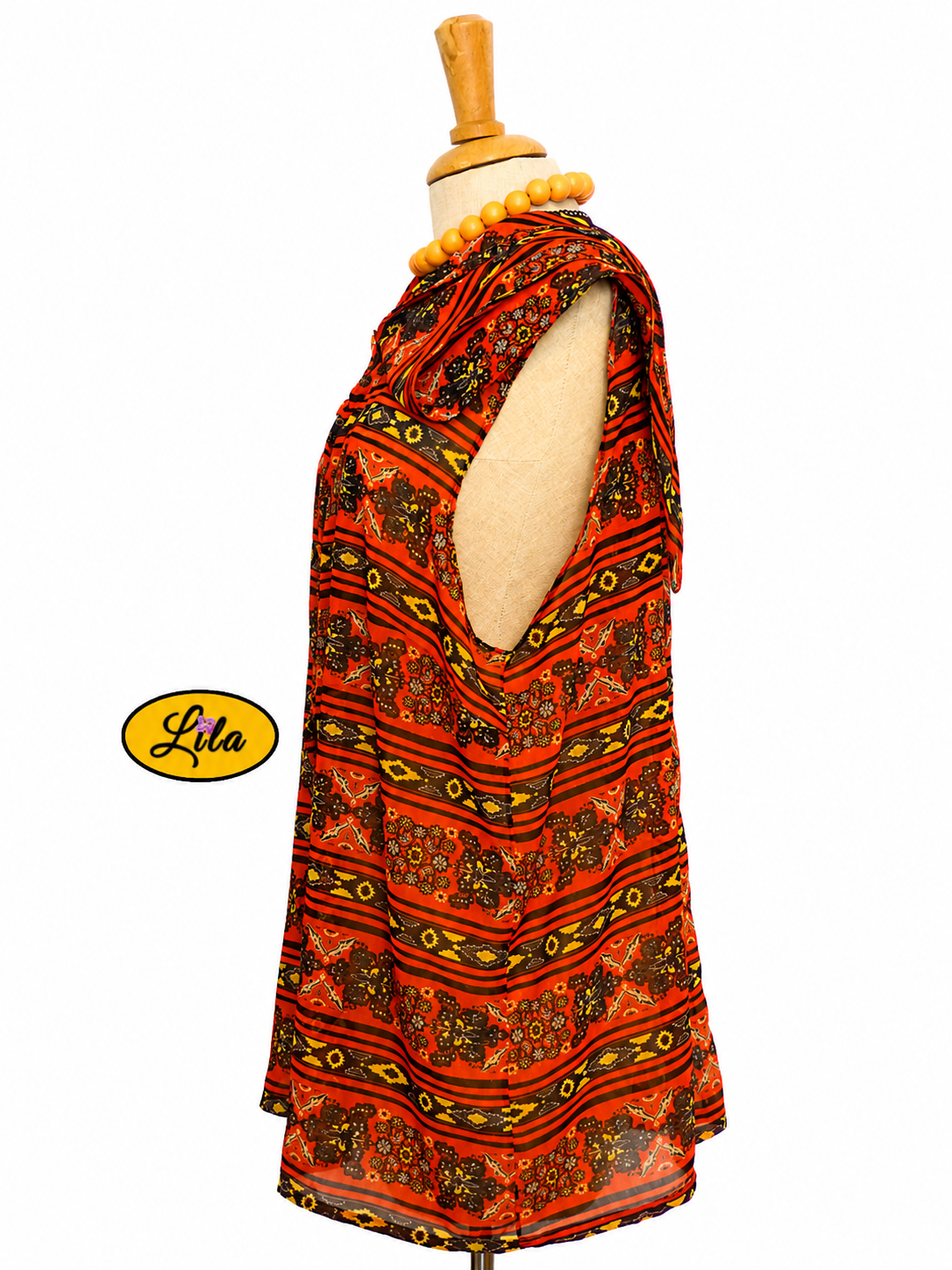Chemisier Delphine sans manches en tissu orange et noir vu de profil droit sur mannequin mettant en valeur les emmanchures échancrées style élégant et moderne