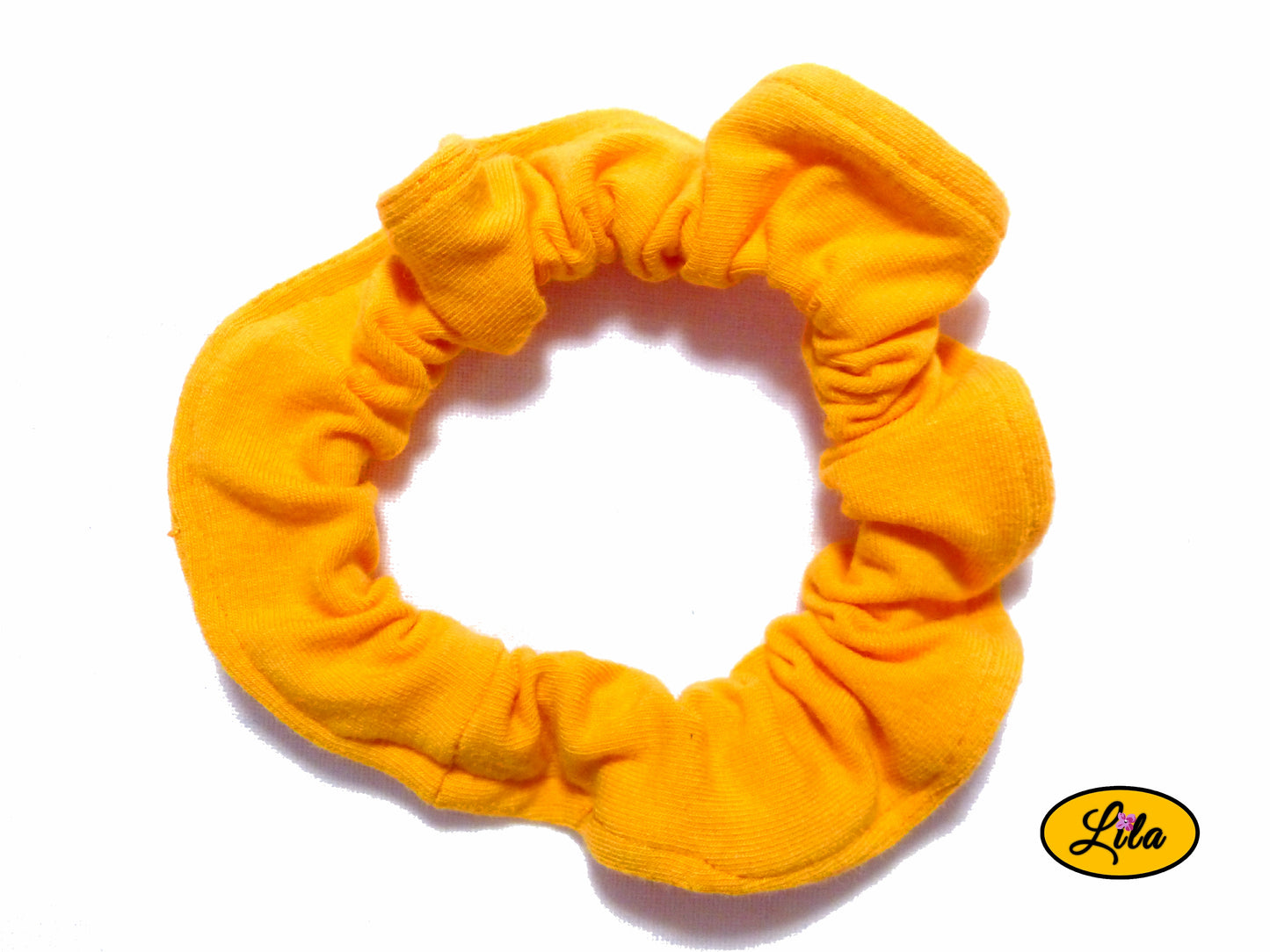 Chouchou pour cheveux en tissu orange uni photographié sous un autre angle sur fond blanc style lumineux et artisanal