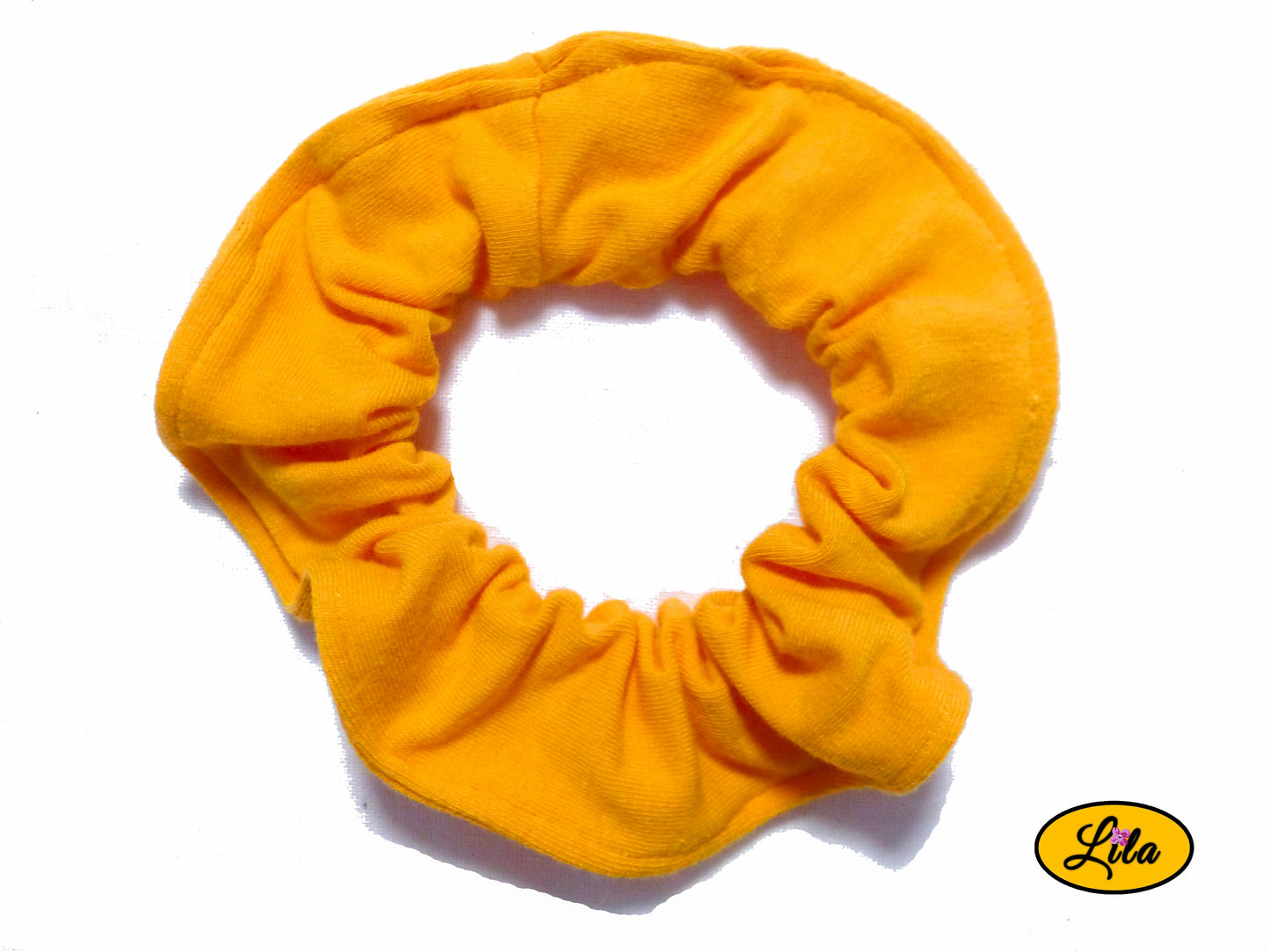 Chouchou pour cheveux en tissu orange uni présenté sur fond blanc style coloré et artisanal