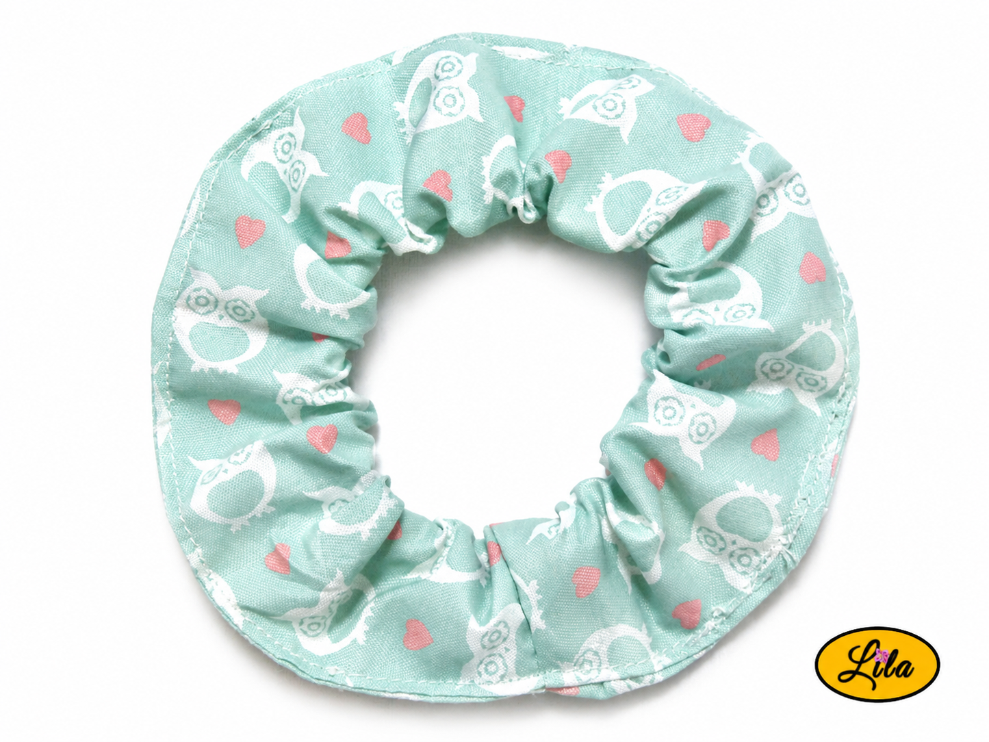 Chouchou pour cheveux en tissu vert menthe à motifs de hiboux blancs présenté sur fond blanc style nature et artisanal