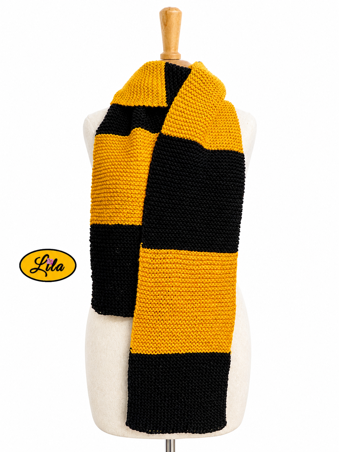 Écharpe tricotée main inspiration Poufsouffle jaune et noir portée sur mannequin de couture sur fond blanc style chaleureux et magique