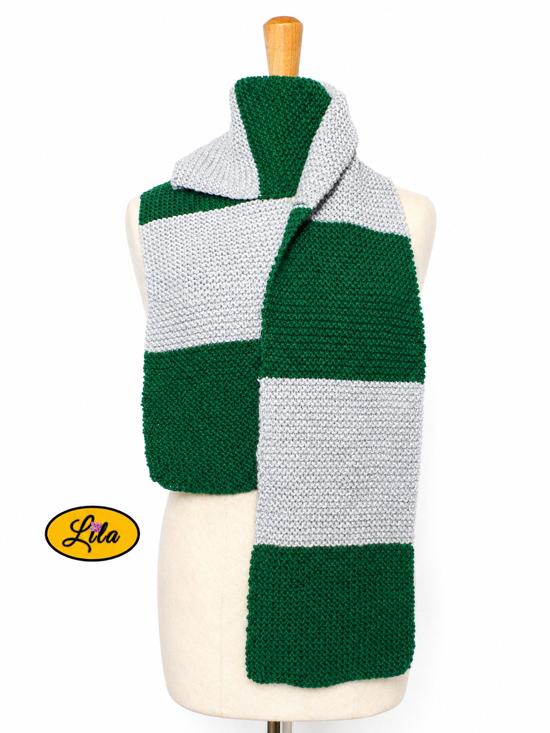 Écharpe tricotée main inspiration Serpentard vert et argent portée sur mannequin de couture sur fond blanc style magique et élégant