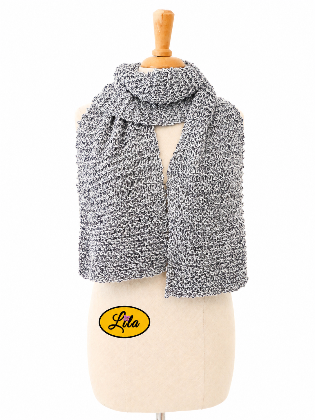 Écharpe tricotée main grise chamarrée enroulée autour d’un mannequin de couture avec extrémités pendantes sur fond blanc style élégant et cocooning