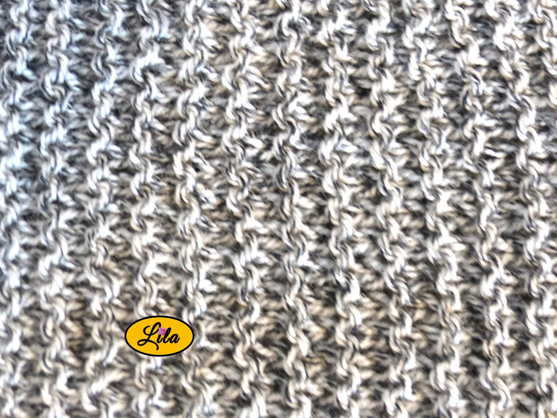 Zoom sur une écharpe tricotée main grise chamarrée avec vue détaillée sur le point de tricot la texture et les nuances de gris style cocooning et artisanal