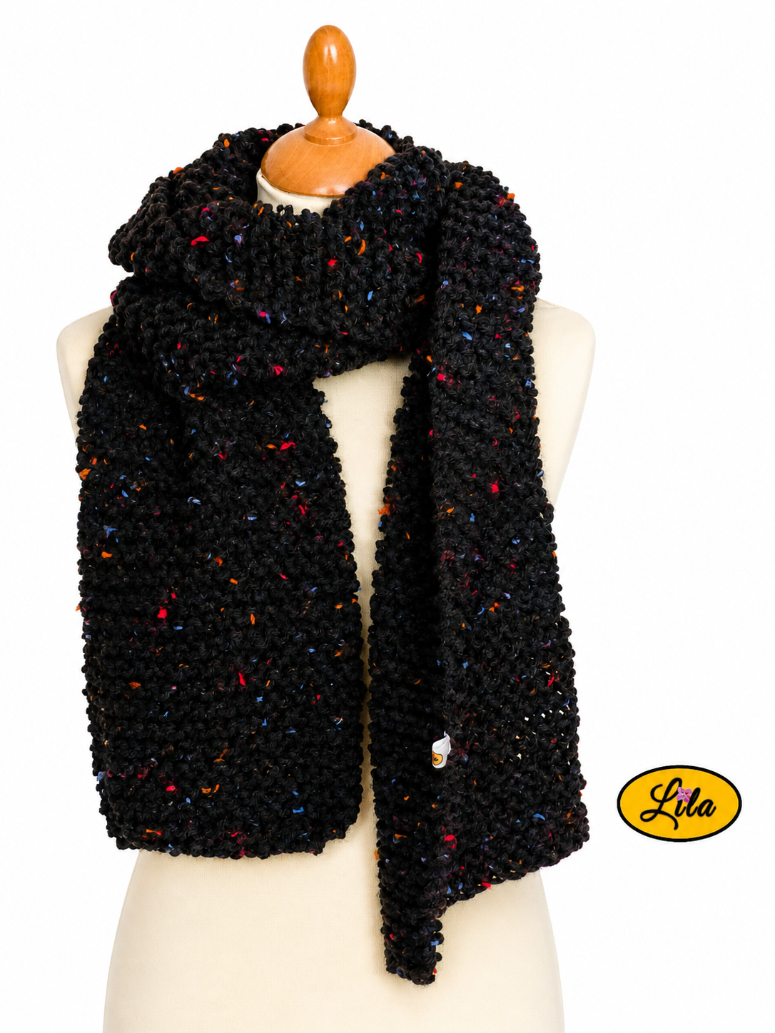 Écharpe en tweed noir tricotée à la main portée sur mannequin de couture avec les deux côtés pendants l’un sur l’autre sur fond blanc style chic et cocooning