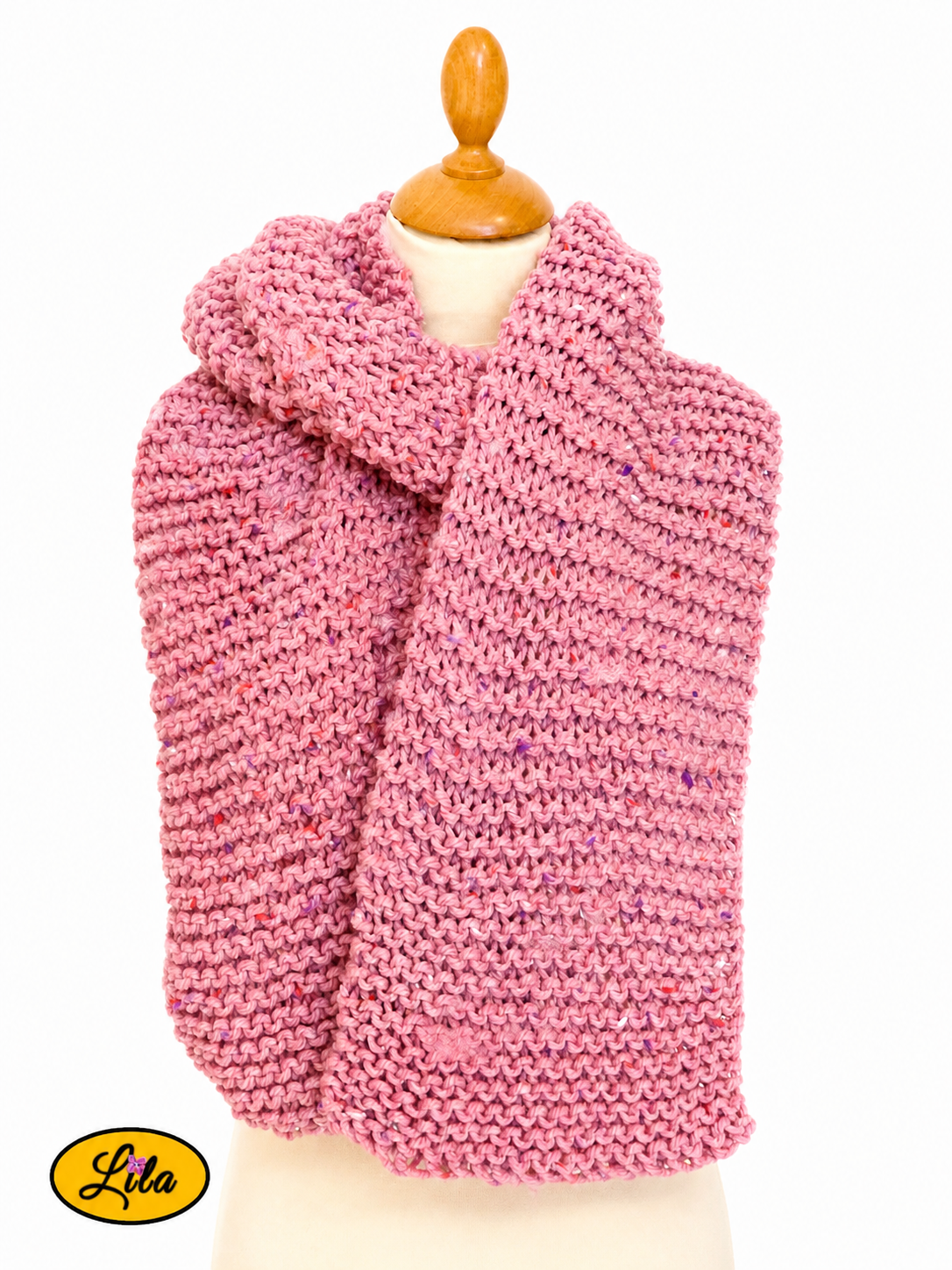 Écharpe en tweed rose tricotée à la main portée sur mannequin de couture avec les deux côtés pendants l’un sur l’autre sur fond blanc style chic et cocooning