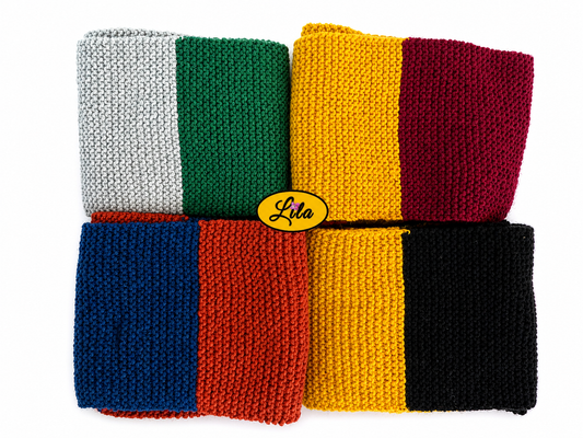 Ensemble de quatre écharpes tricotées main inspiration Harry Potter aux couleurs des maisons Gryffondor Serpentard Poufsouffle et Serdaigle pliées sur fond blanc