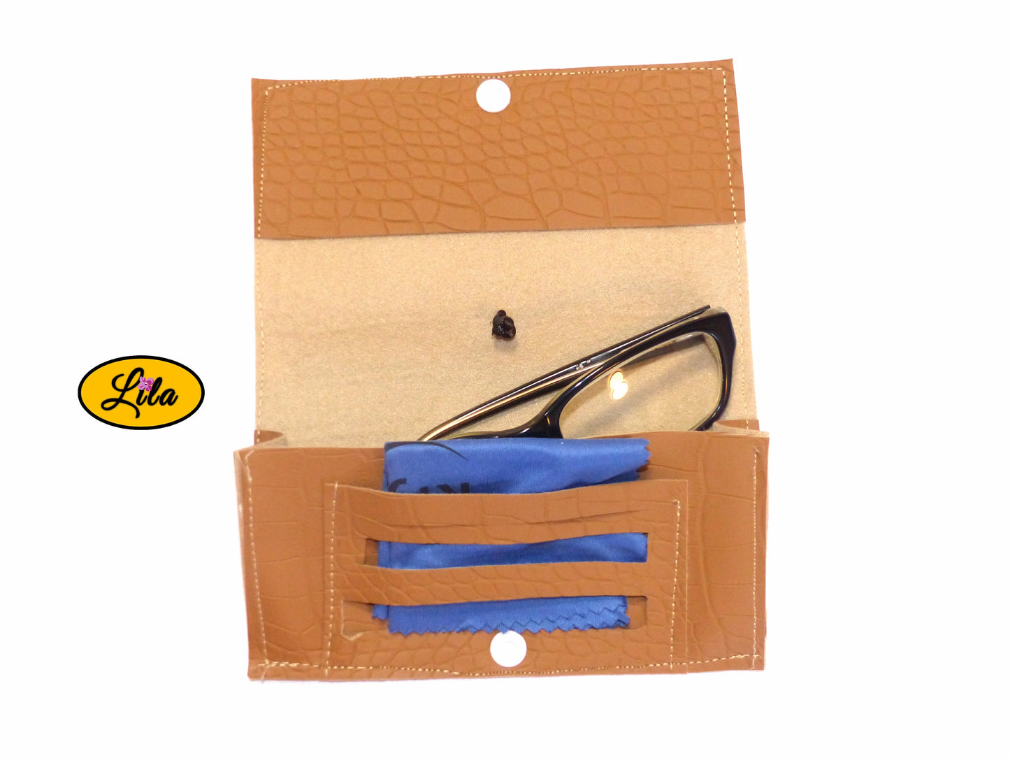 Étui à lunettes en simili brun craquelé ouvert à plat avec paire de lunettes et lingettes rangées dans le compartiment intérieur sur fond blanc style artisanal et fonctionnel