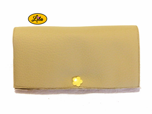 Étui à lunettes en simili crème avec attache pression en forme de fleur jaune fermé avec lunettes à l’intérieur sur fond blanc style moderne et féminin