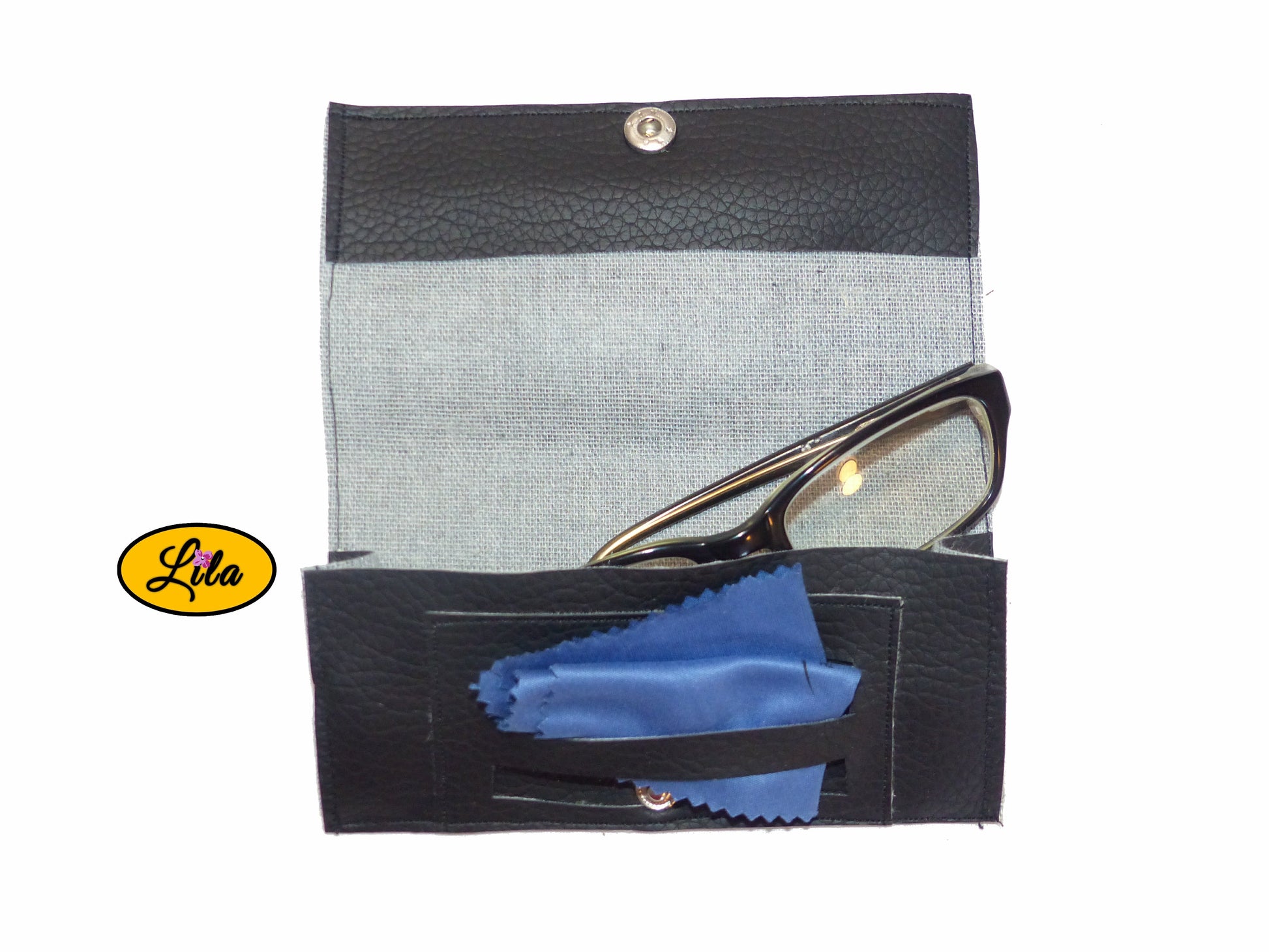 Étui à lunettes en simili noir avec attache pression argentée ouvert à plat avec paire de lunettes et lingettes rangées dans le compartiment intérieur sur fond blanc style chic et fonctionnel