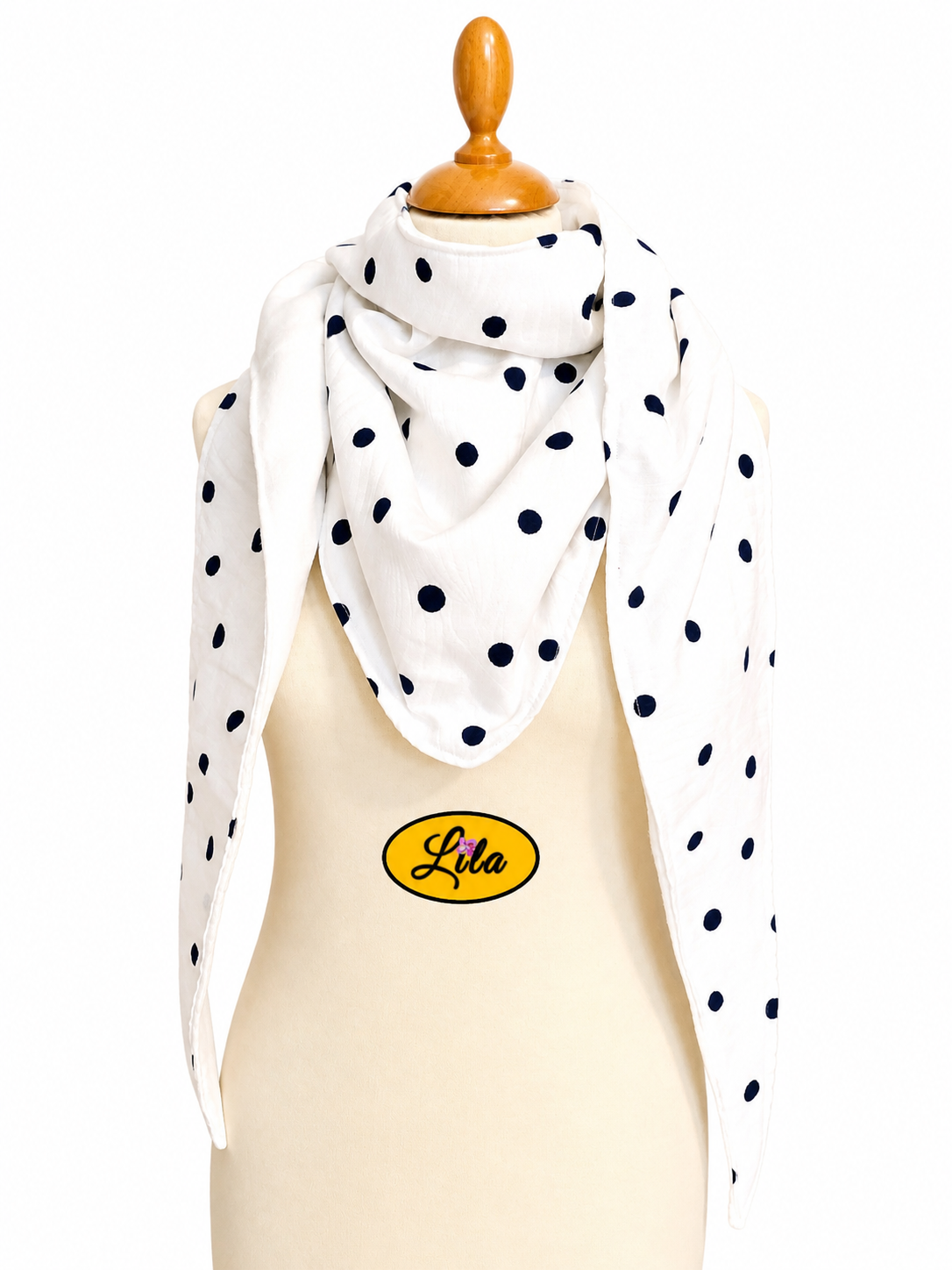 Foulard triangulaire blanc à pois bleu marine avec doublure polaire blanche porté sur mannequin de couture sur fond blanc style rétro et hivernal