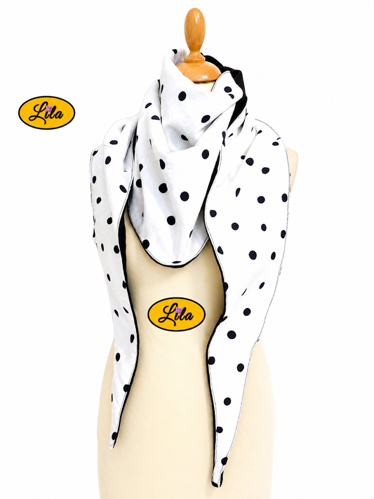 Foulard triangulaire blanc à pois noirs avec doublure polaire noire porté sur mannequin de couture sur fond blanc style rétro et hivernal